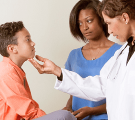 doctor examine child while mother looks on
