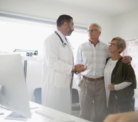doctor speaking with an elderly couple